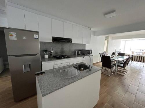 普库萨纳Apartamento Mar Naplo的厨房配有不锈钢冰箱和桌子