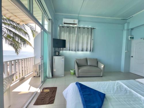 奈汉海滩Naiharn On The Rock Resort Phuket的卧室设有1张床和1把椅子,位于阳台