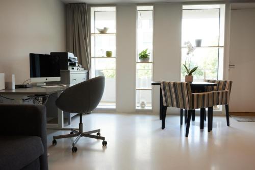 尼翁NYON - Appartement meublé tout confort的客房设有带电脑和椅子的书桌。