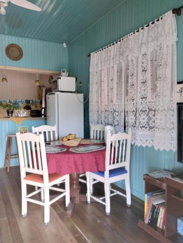 特拉曼达伊Pousada Atlântica stay home的厨房配有桌椅和冰箱。