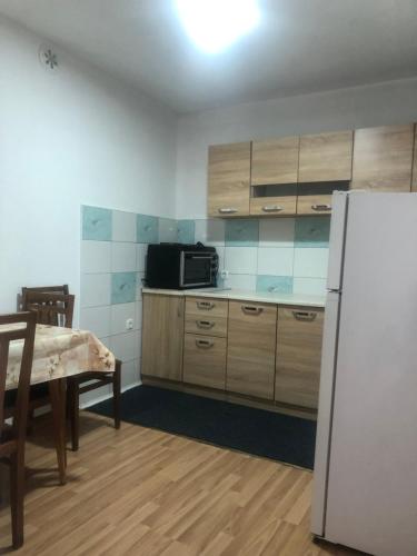 马夫罗沃Petar Apartment的厨房配有白色冰箱、桌子、桌子和桌子。