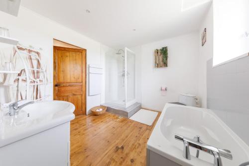 La SoucheLE CLOS DU MOUY的白色浴室设有2个水槽和木地板。