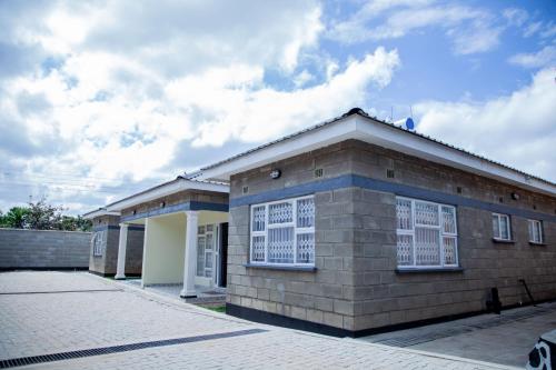 MzuzuThe N3 Suites的一座小砖砌建筑,上面有白色的窗户