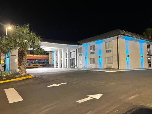 克利尔沃特Rodeway Inn Clearwater - Central的停车场里一座蓝色灯的大建筑