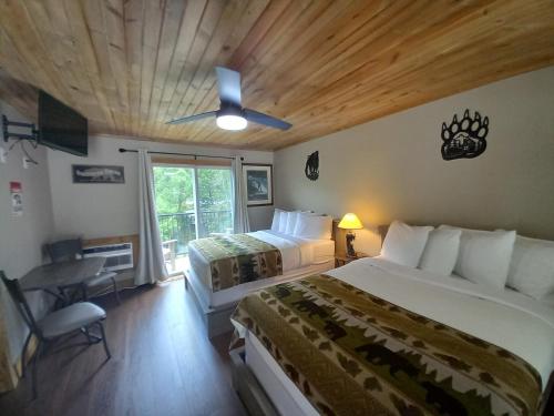 烟囱岩Carter Lodge - On The River的一间卧室设有两张床、一张桌子和一个窗口。