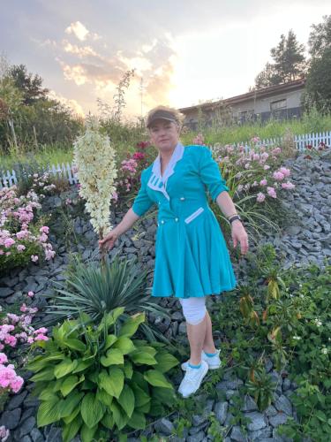 莱沃恰Villa Mia的站在花园中的身着蓝色衣服的女人
