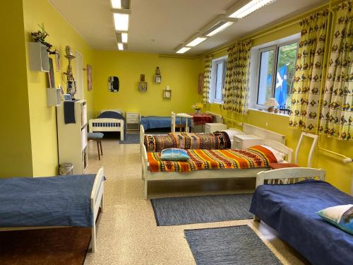 IideTorgu Royal Guesthouse的一间设有几张床的客房,位于拥有黄色墙壁的房间