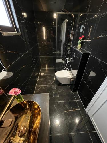 安曼Amman villa的一间带金色水槽和卫生间的浴室