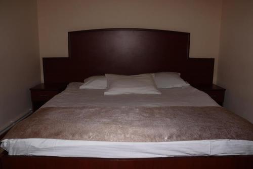 斯捷潘纳万RL Hotel的一张带棕色床头板和白色枕头的床