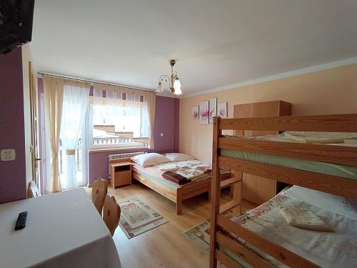 Leśnicau Marii Gał的客房设有两张双层床和一张桌子。
