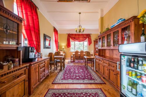 吕德里茨Alte Villa Gästehaus的一间厨房和带红色窗帘的用餐室