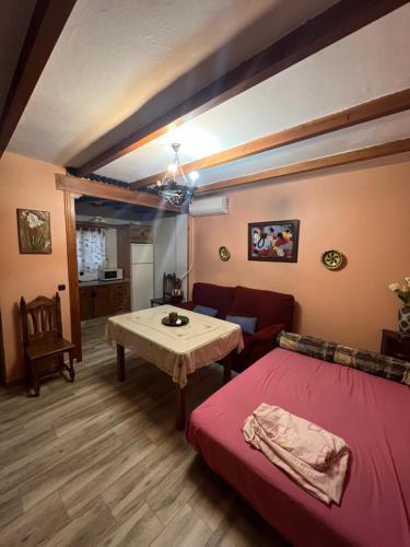 隆达Apartamento Cerro De Las Salinas的客厅配有红色的床和桌子