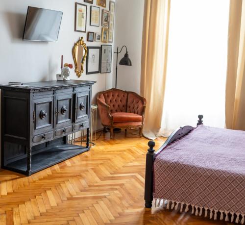 蒂米什瓦拉Maxim's place的一间卧室配有一张床、梳妆台和椅子