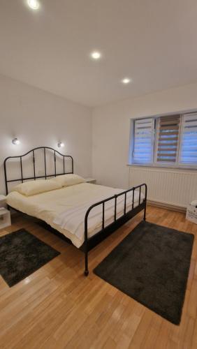 萨格勒布Apartman Roses的卧室配有一张床铺,地板上铺有2个地毯。