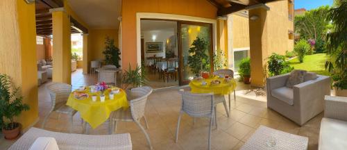 维拉西米乌斯Hotel Il Girasole的庭院设有两张带黄桌布的桌子