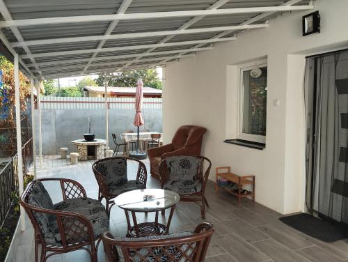 豪伊杜索博斯洛Stella Apartman的门廊上设有带椅子和桌子的天井。
