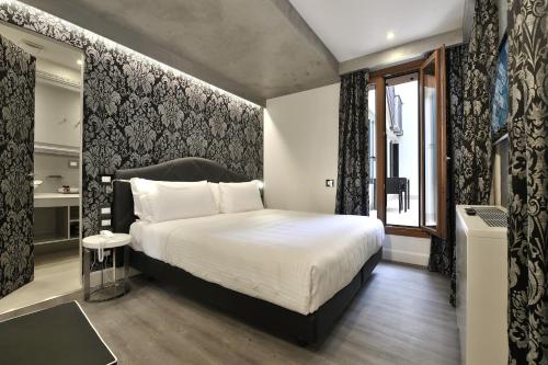 威尼斯剧院宫酒店的一间卧室设有一张大床和一个窗户。