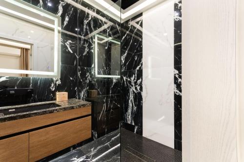 基希讷乌Luxury apartment close to the city centre的带淋浴和盥洗盆的黑色浴室