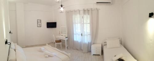 达西亚Pericles Apartment的白色的客房配有两张床和一张书桌