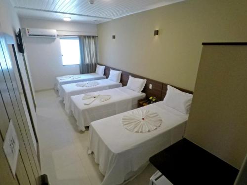 塞古罗港MIRAGE HOTEL的酒店客房设有三张床和窗户。