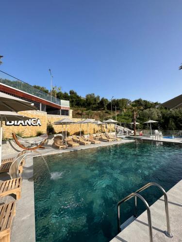 地拉那Bianca Hotel & Villa的一个带躺椅的游泳池和一个游泳池