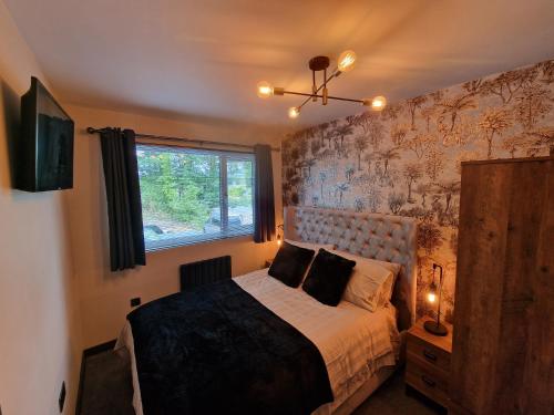 鲍内斯温德米尔Bowness - 3 Bed - Hot Tub House的一间卧室设有一张床和一个窗口