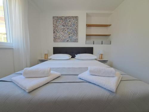 布罗达里卡Holiday house SeaDream - 50 meters from the sea的白色卧室配有一张带两个枕头的大床