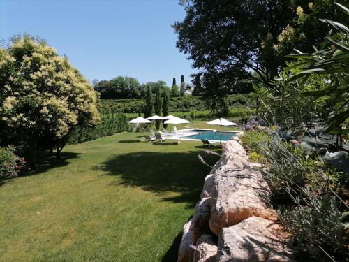 明乔河畔的瓦雷奇奥Relais Ca' Morenica的一个带遮阳伞和石墙的花园
