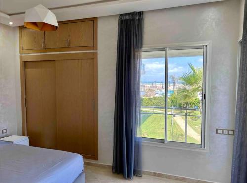 西迪拉哈尔Cosy Apartment with sea view的一间卧室设有一张床和一个大窗户
