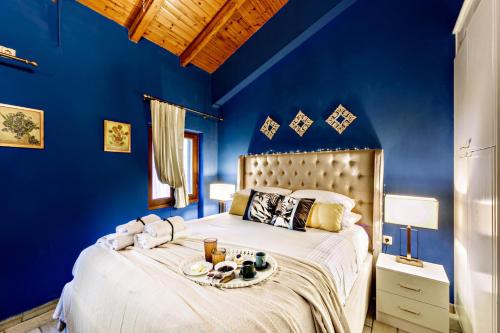 科孚镇Via Porta Raimonda (Luxury central detached house)的蓝色的卧室,配有一张床和食物托盘