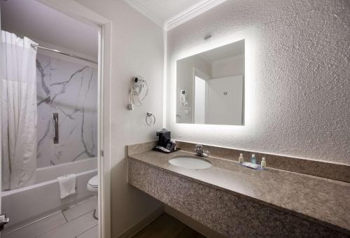 塔拉哈西Quality Inn Tallahassee near University的一间带水槽和镜子的浴室