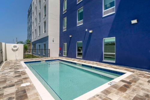 新里奇港Comfort Inn & Suites New Port Richey Downtown District的蓝色建筑前的游泳池
