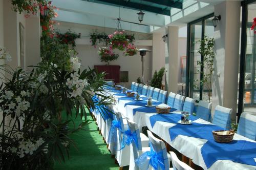 索非亚科尼亚兹波利斯酒店的长排的桌子,上面有蓝色的餐巾和鲜花