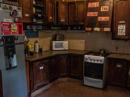 康考迪亚DCH Hostel Backpaquers的厨房配有木制橱柜、炉灶和微波炉。