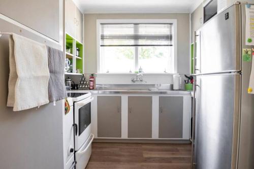 陶波Turangi Home Family Size的厨房配有水槽和冰箱