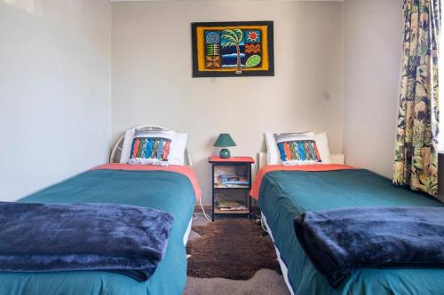 陶波Turangi Home Family Size的卧室配有两张床,墙上挂着一幅画
