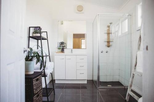 本迪戈Hargreaves Cottage - close to CBD的白色的浴室设有水槽和淋浴。