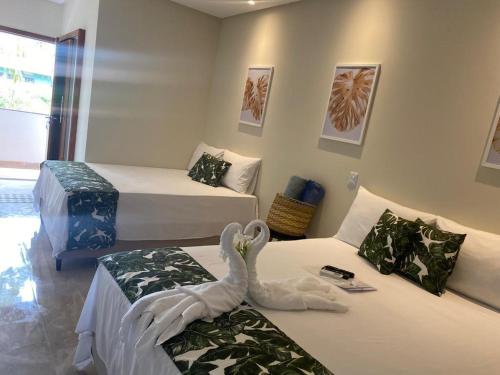 阿拉亚尔达茹达Santorini Beach Hotel的一间设有两张床的房间,上面有天鹅