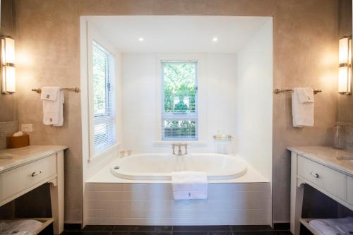 纳尔逊Pihopa Retreat的白色的浴室设有窗户,配有浴缸