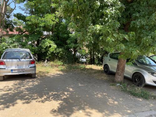 弗拉涅Bora Apartmani - FREE PARKING - CITY CENTER的两辆汽车在树下相互停放