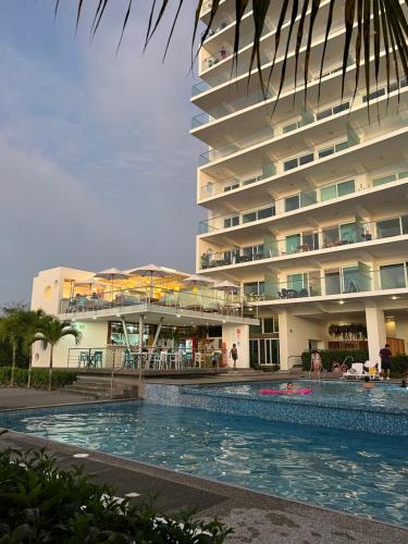 通苏帕Resort Playa Azul Departamentos frente al mar的大楼前设有游泳池的酒店