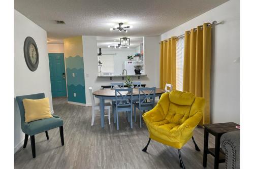 彭萨科拉Coral Sky的客厅设有餐桌和黄色椅子