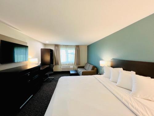 威斯康星戴尔Sleep Inn & Suites Lake Delton-Wisconsin Dells Newly Renovated 2024的一间酒店客房,配有一张大床和一台平面电视