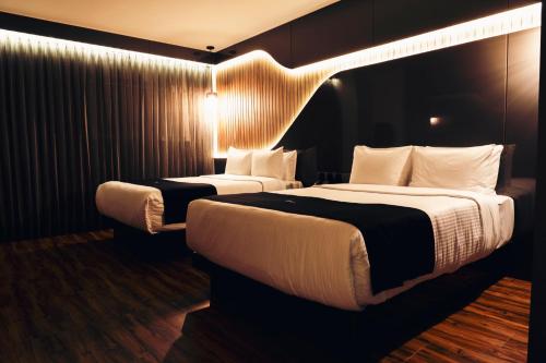 克雷塔罗Hotel Yoru的酒店客房带两张床和灯