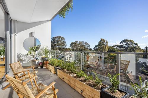 悉尼FINL503LC - Finlayson Heights的大楼内的阳台配有椅子和植物