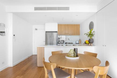 悉尼FINL503LC - Finlayson Heights的厨房以及带木桌和椅子的用餐室。