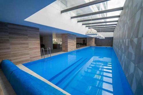 基多Suite Martina 2 Personas Quito的大楼内的一个蓝色海水游泳池