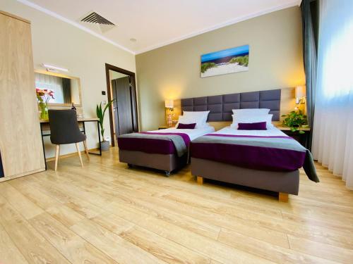 克拉科夫Hotel CONRAD Comfort的酒店客房配有两张床和一张书桌