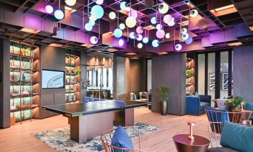 芭堤雅市中心Condo Edge Central的一间设有桌子和紫色照明的用餐室