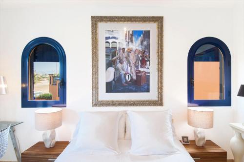 梅罗那瑞斯Meloneras Suites的一间卧室设有2扇窗户和1张带2个枕头的床